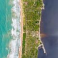 Um verde mar de um lado e uma água escura do outro dividido por um pedaço de terra