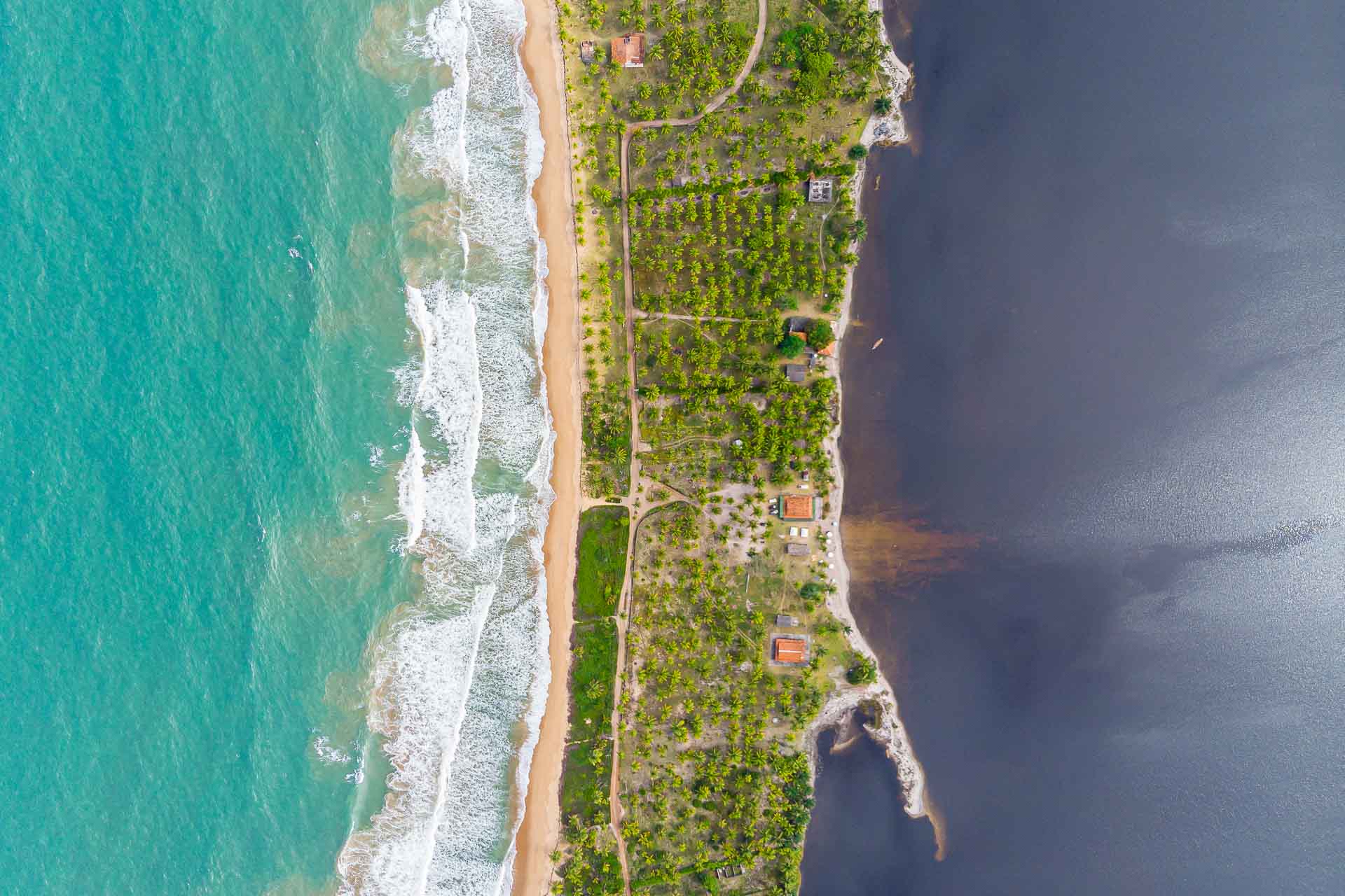 Um verde mar de um lado e uma água escura do outro dividido por um pedaço de terra