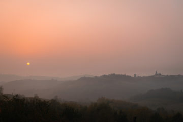 The sun setting in the horizon in a pinkish sky in Slovenia