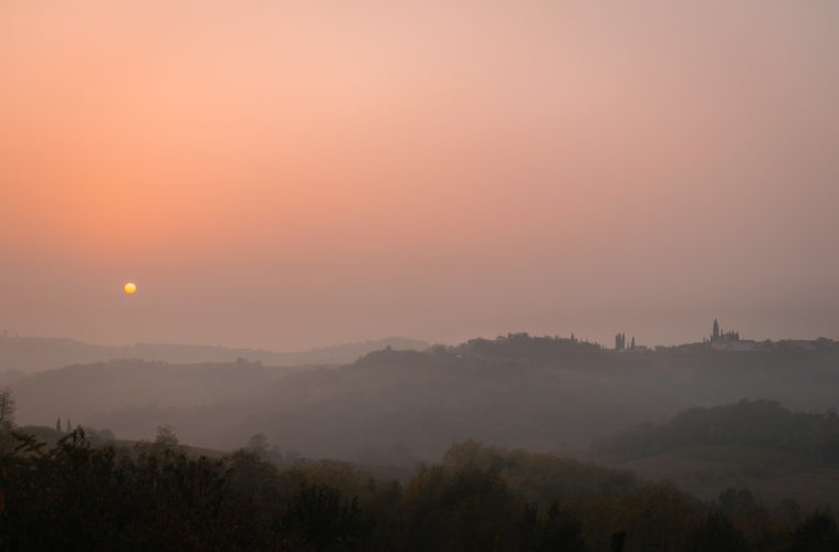 The sun setting in the horizon in a pinkish sky in Slovenia