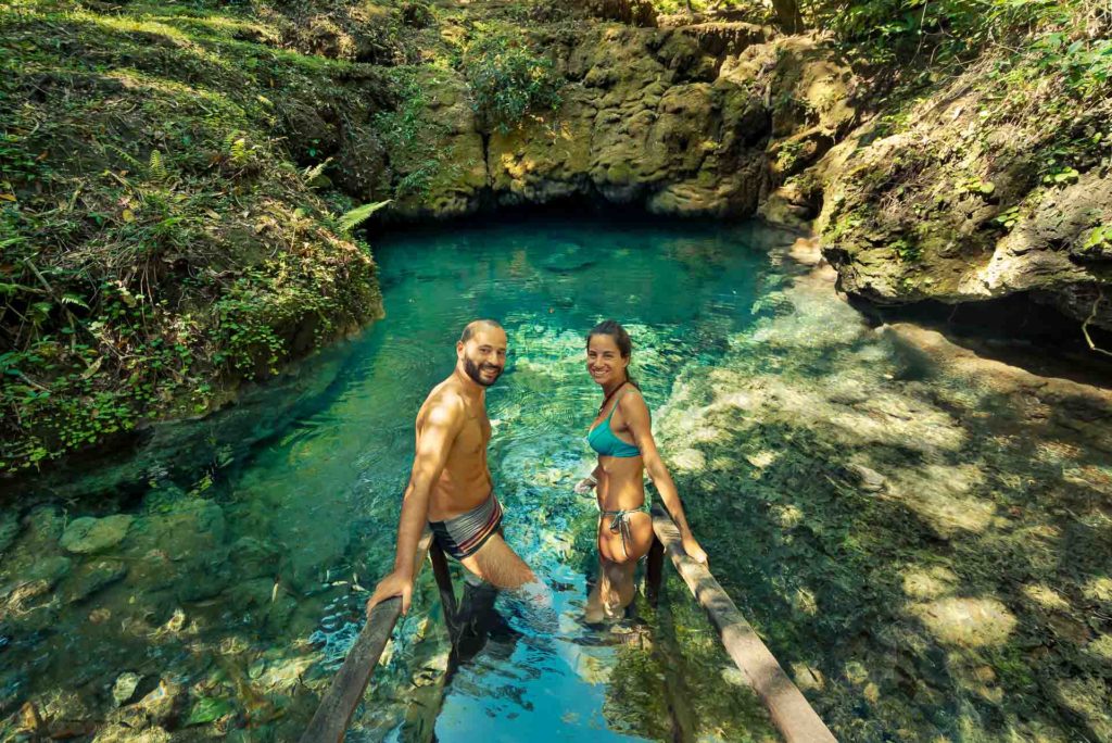 Tiago e Fernanda na frente de um poço de água cristalina na Serra da Bodoquena