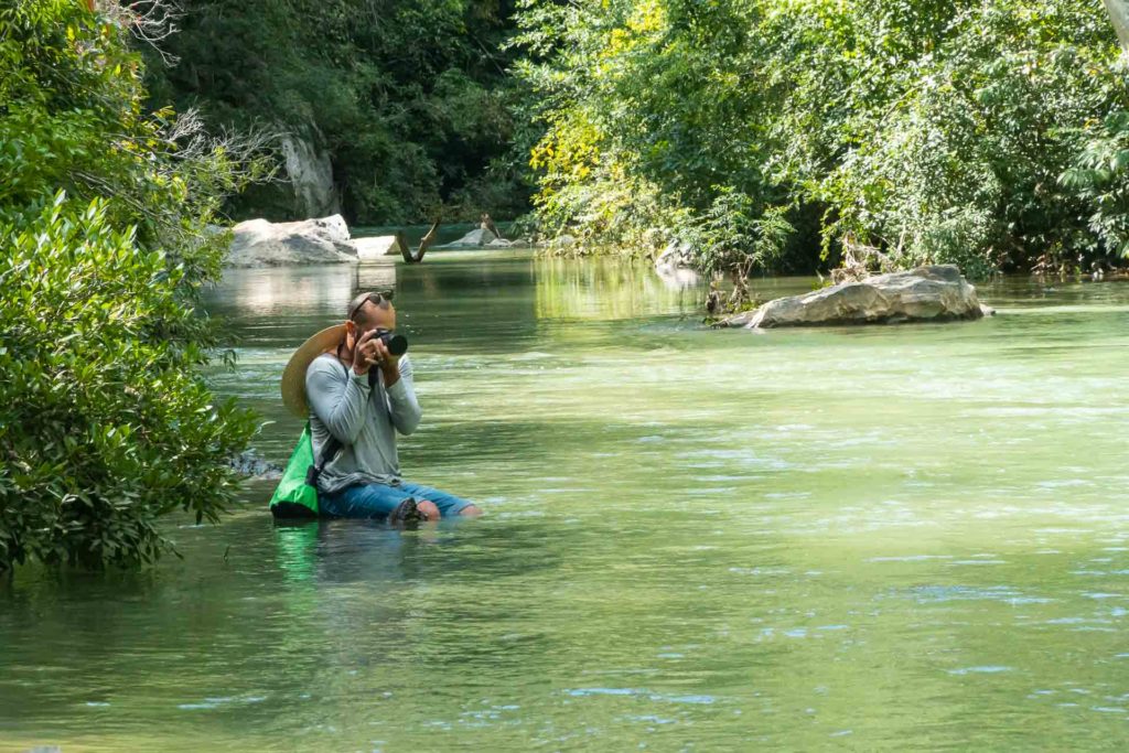 Tiago taking a photo in the middle of the river