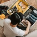 Man packing his bag to travel to fit everything he needs in a bag