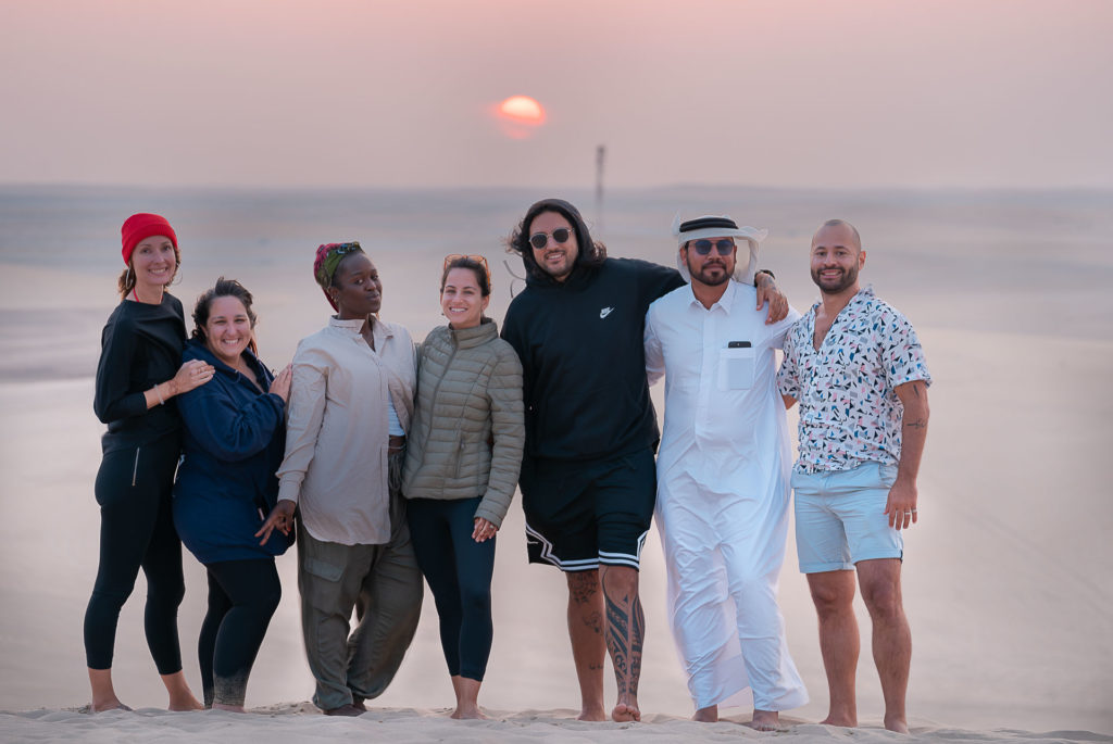 Grupo pousando para foto durante o por-do-sol no deserto do Catar