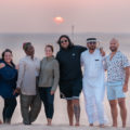 Grupo pousando para foto durante o por-do-sol no deserto do Catar