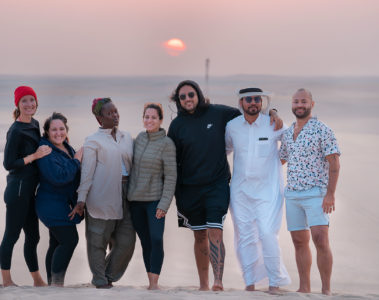 Grupo pousando para foto durante o por-do-sol no deserto do Catar