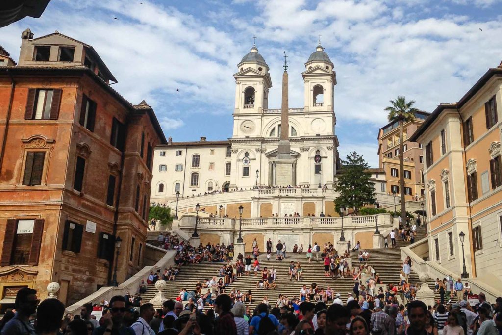 Piazza di Spagna in Rome with many people on the Spanish steps in front of the church