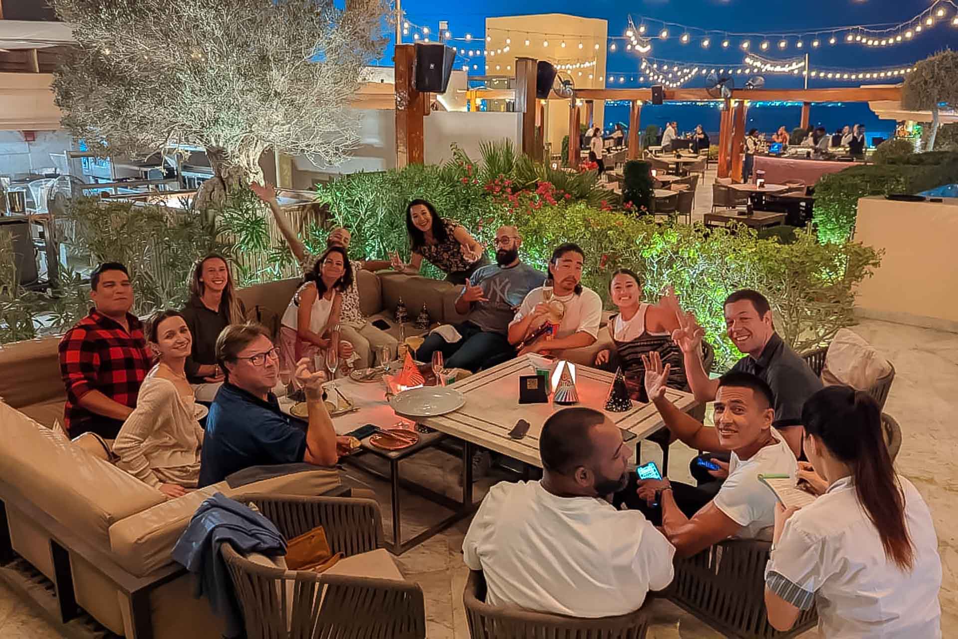 Um grupo de pessoas sentadas em uma mesa em um bar no terraço de um prédio alto do Catar para brunch