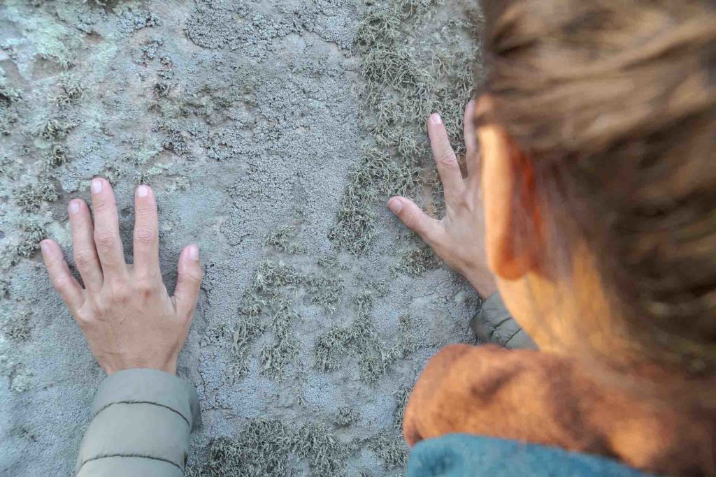 Fernanda tocando as pedras de Stonehenge com suas mãos 