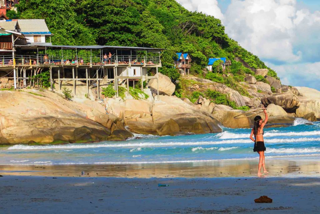 Uma garota fazendo malabares com seu bambolê na praia de Haad Rin, onde acontece a Festa da Lua Cheia