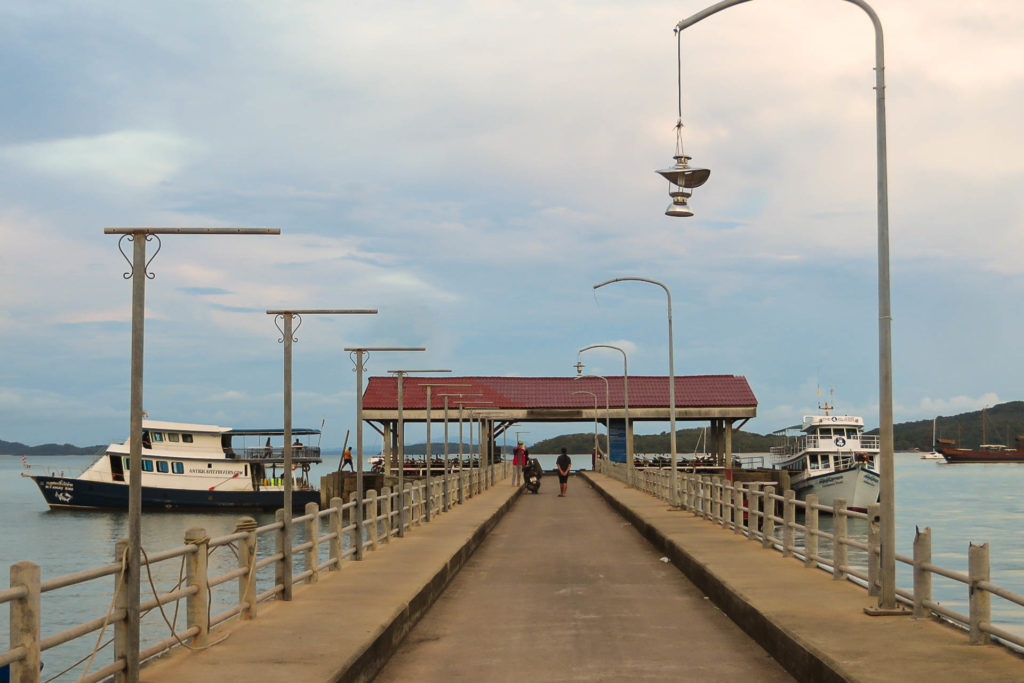 A long pier with two boats parked near it