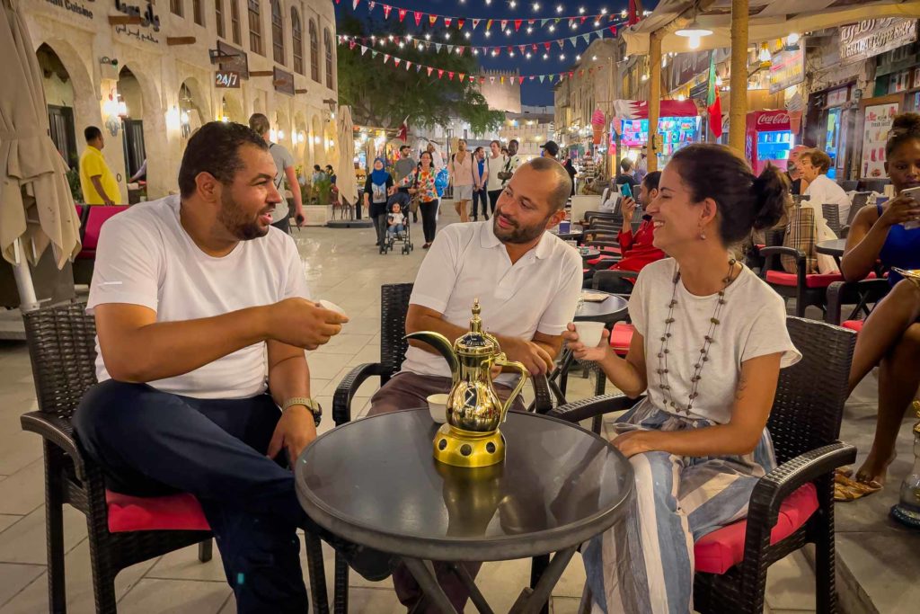 Tiago, Fernanda e um amigo bebendo café árabe no mercado de rua de Souq Waqif em Doha
