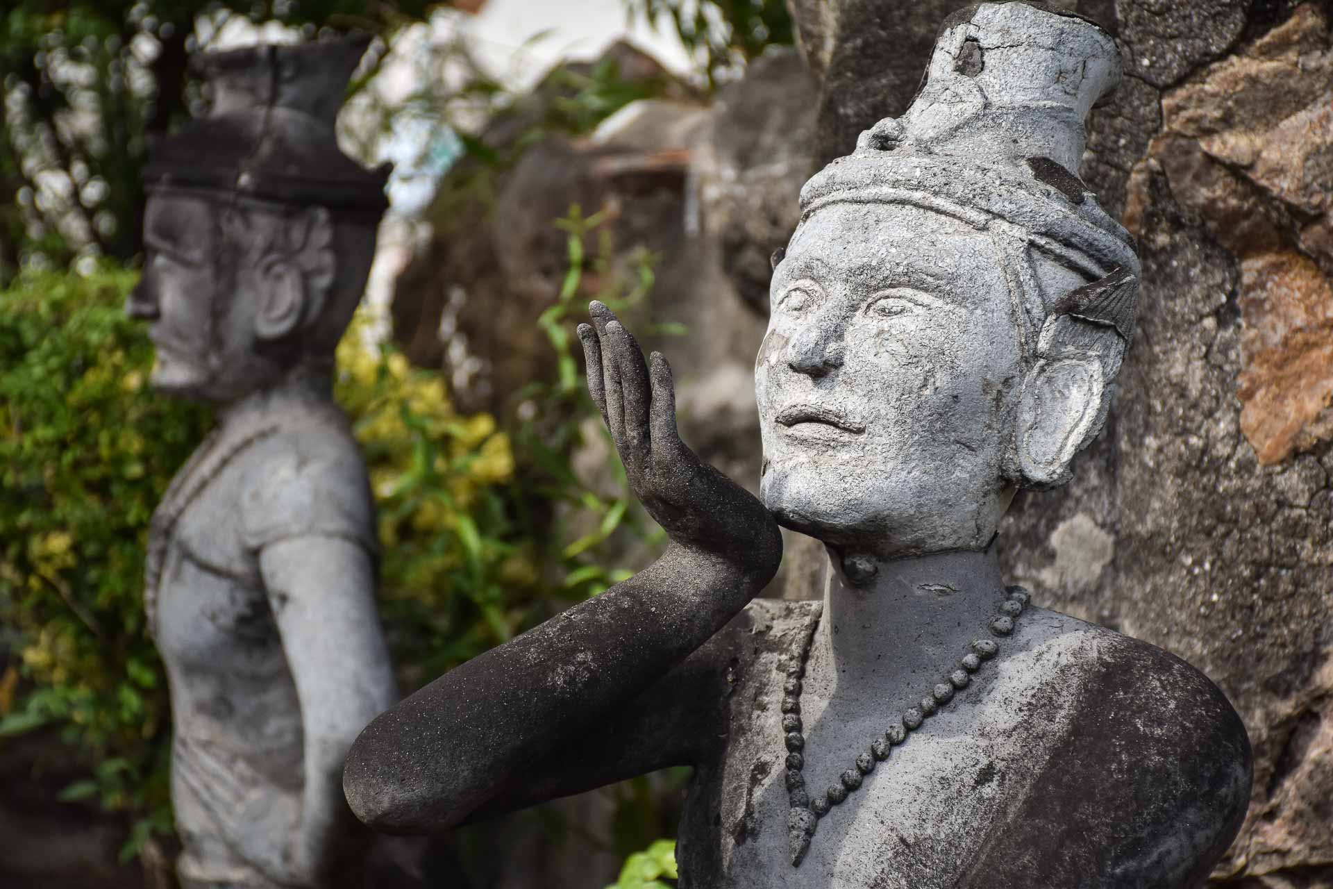 Uma estátua com a mão na frente da boca como se estivesse mandando um beijo na Tailândia