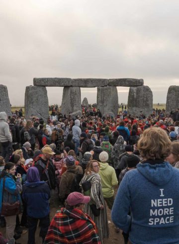 Many people in the middle of the Stonehenge circle