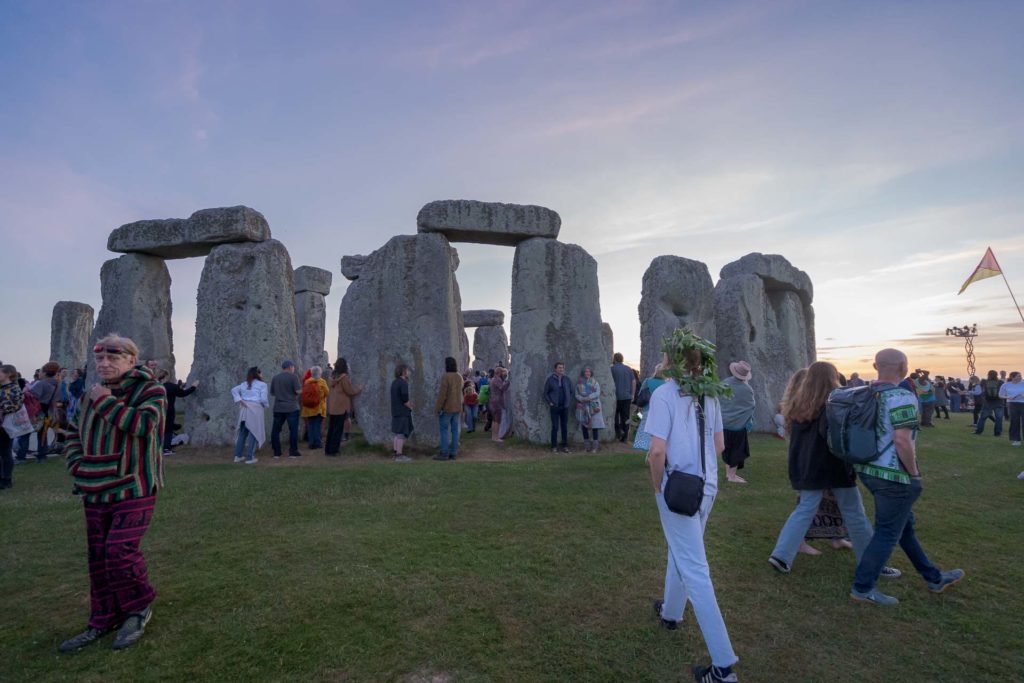 Pessoas andando em volta das pedras de Stonehenge na Inglaterra durante o solstício de verão