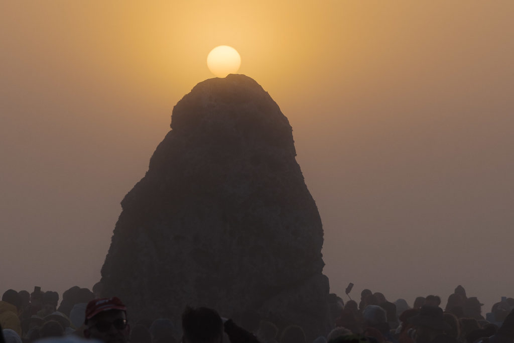 Sun rising from the northern rock during the Stonehenge Summer Solstice