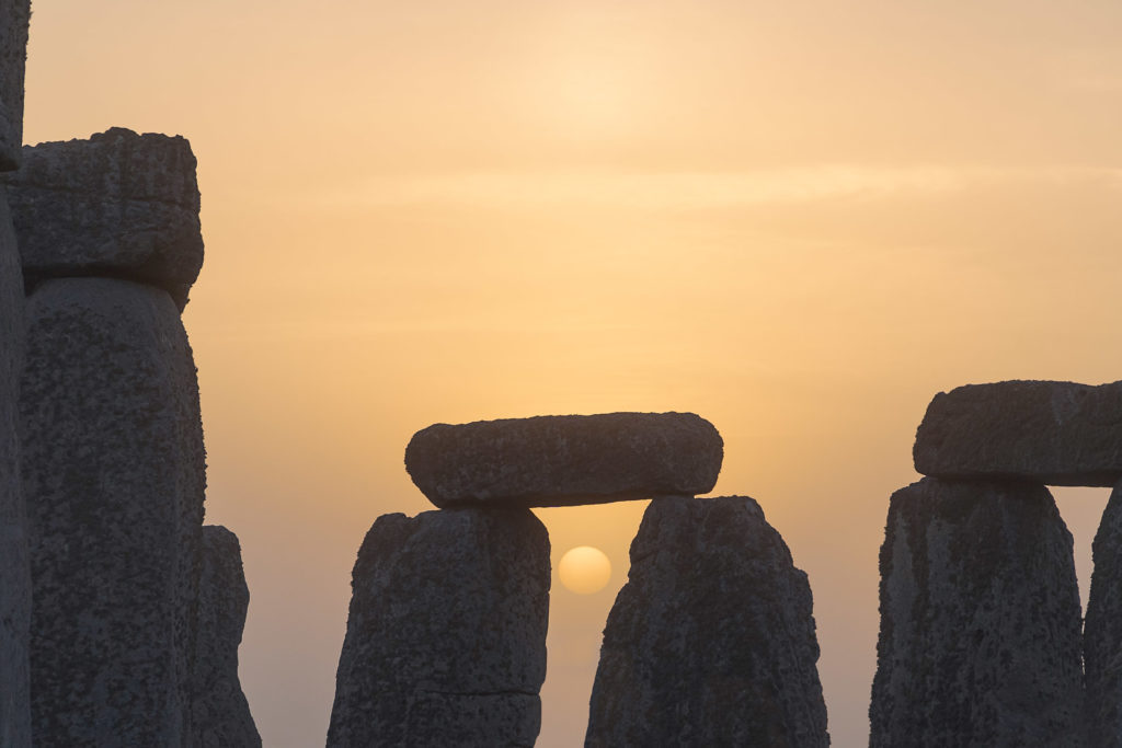 O sol nascendo no meio das pedras de Stonehenge na Inglaterra durante o sosltício de verão