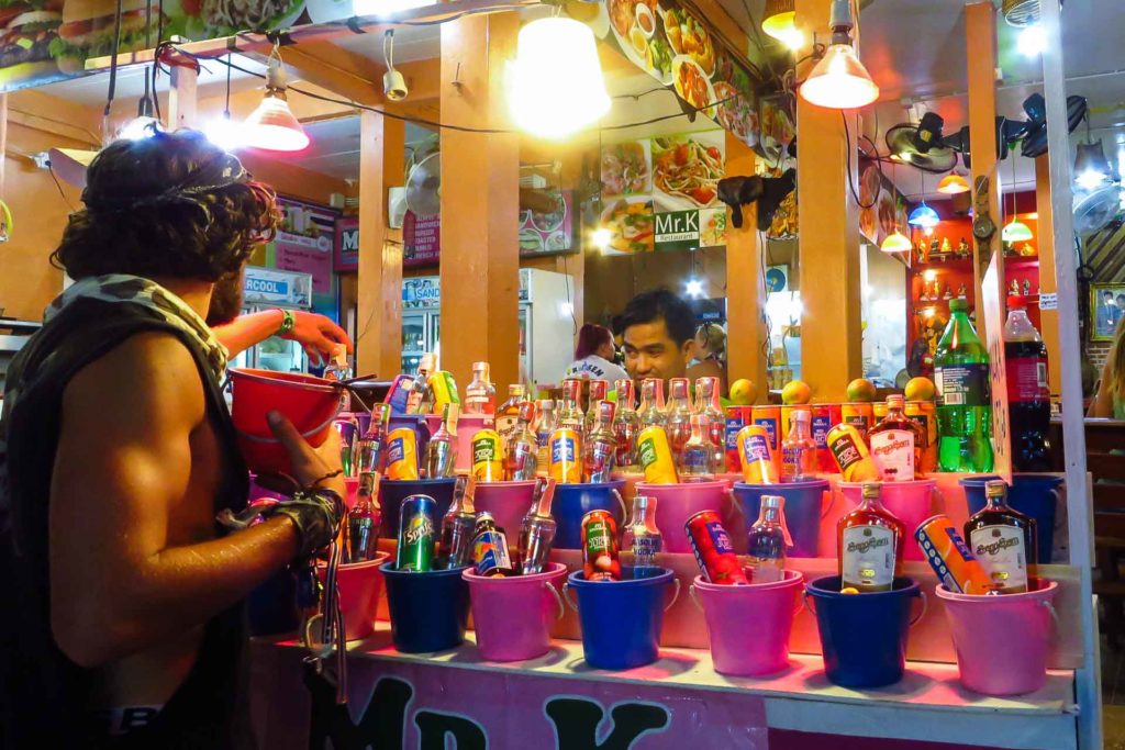 Um rapaz comprando o baldinho de álcool em uma das barracas da Festa da Lua Cheia