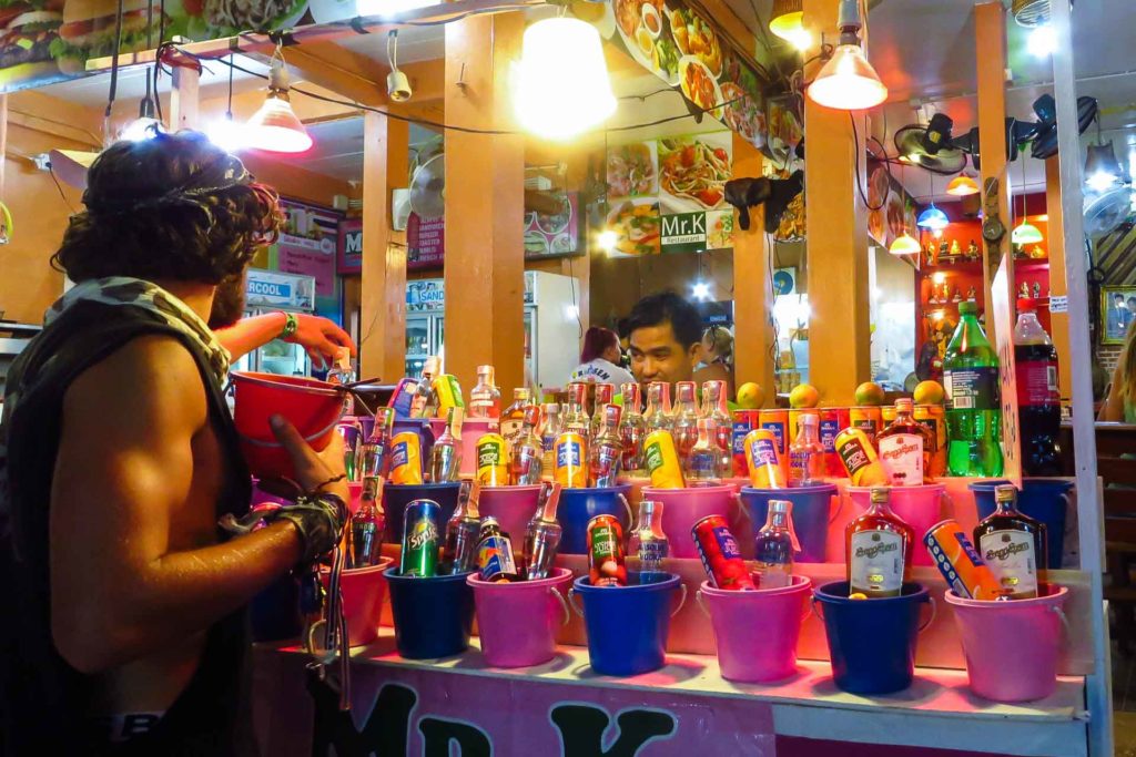 A man buying the alcohol buckets in a stall in Thailand