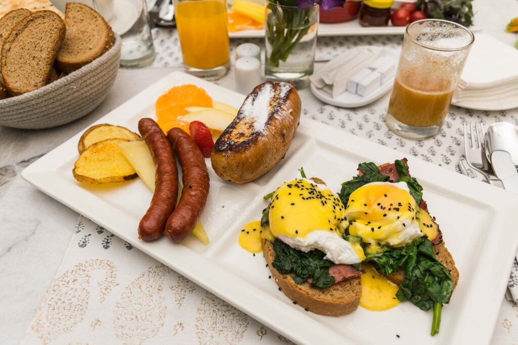 A food plate with sausages, pouched egg, juice, and a full breakfast at the hotel in Tehran