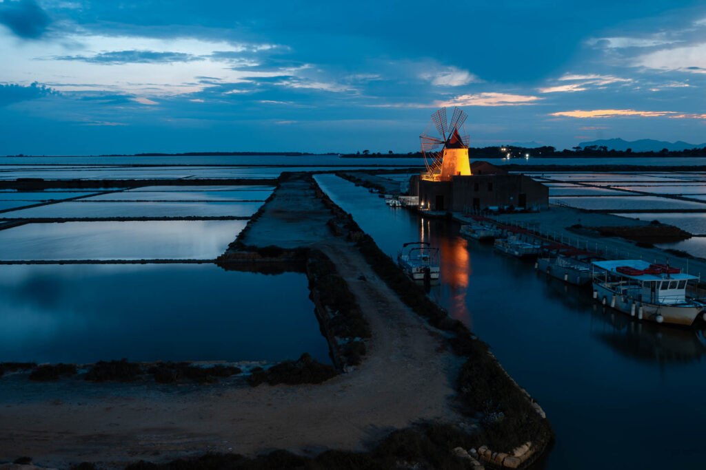 The Salina in front of Favignana with a windmill lighted in yellow during dusk