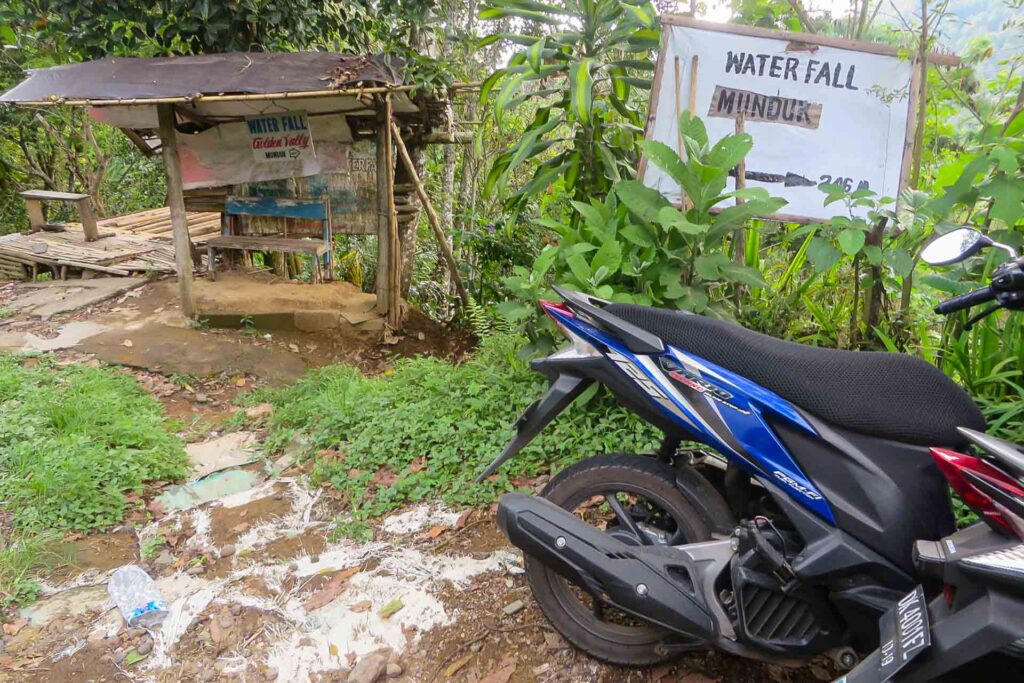 A motorbike parked in front of the entrance of Munduk Waterfall during a tour in Bali