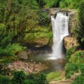 The large Tegenungan waterfall falling in a pool swimming by many people