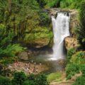 A grande cachoeira de Tegenungan caindo em um lago com muitas pessoas nadando