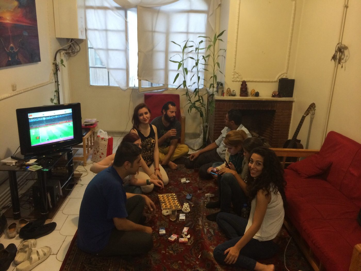 Group of friends in a room with a TV in Tehran